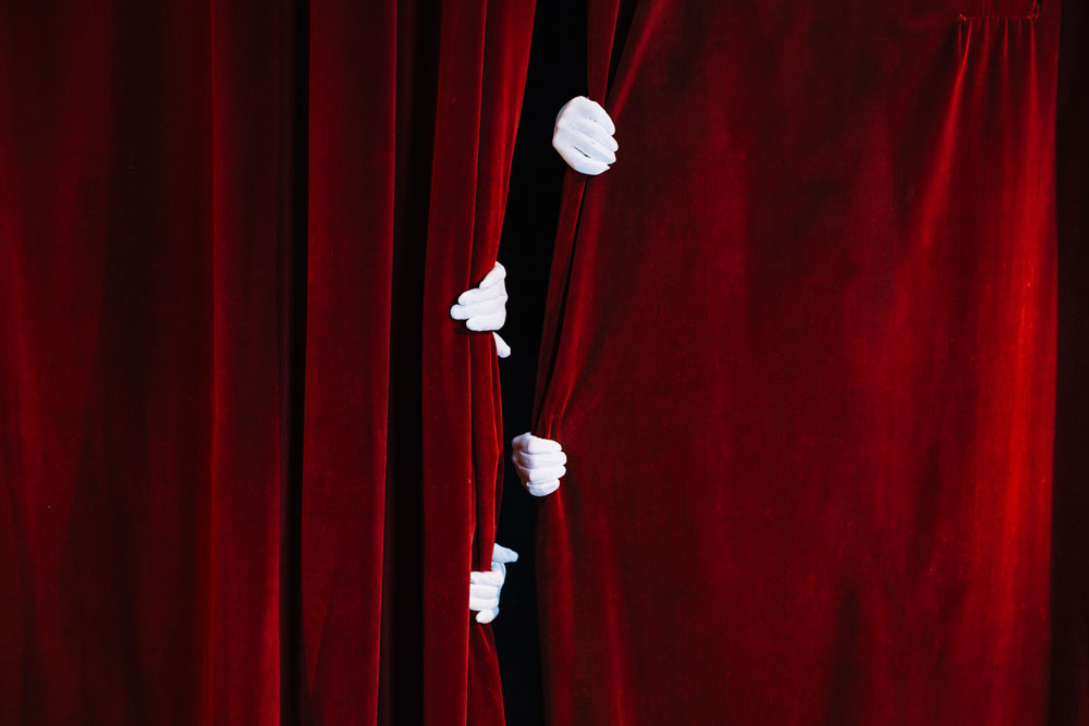 mime-s-hand-holding-closed-red-curtain-web